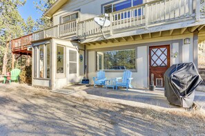 Une maison à deux étages avec un balcon, une terrasse couverte avec des chaises et un garage.