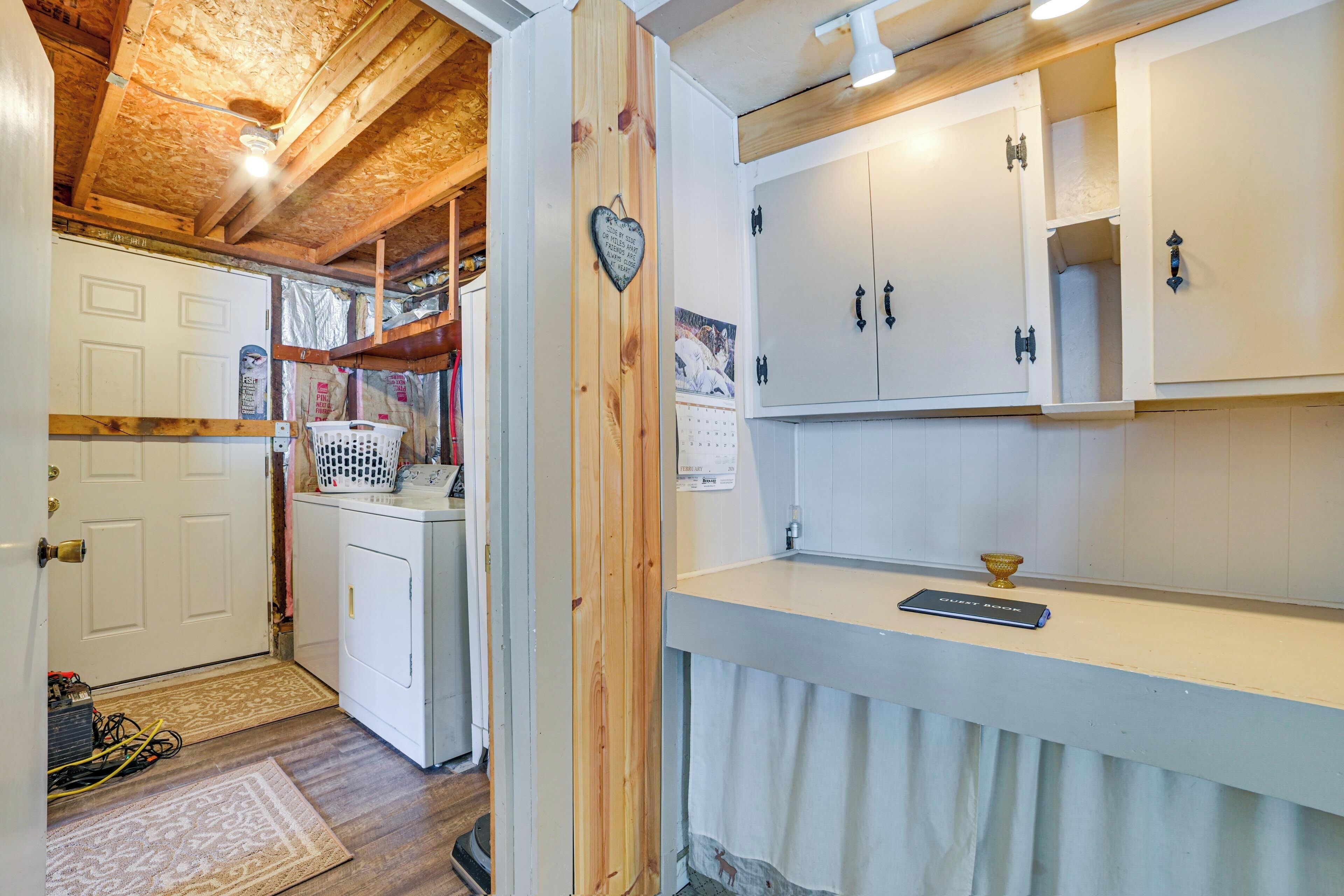 A laundry area with a washing machine, a drying rack, and a heart-shaped decoration on the wall.
