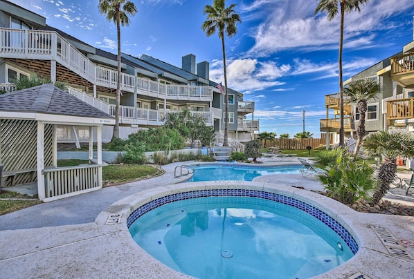 A hotel with a pool area, multiple balconies, and palm trees. - Beach Getaway on Mustang Island: Pet Friendly! (Port Aransas)