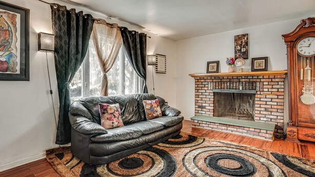 A living room with a leather sofa, a fireplace, and a clock. - 2 Mi to UBS Arena & Belmont Park: Suburban Escape (Elmont)