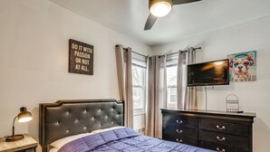 A bedroom with a bed, a dresser, a TV, and a motivational quote on the wall. - 2 Mi to UBS Arena & Belmont Park: Suburban Escape (Elmont)