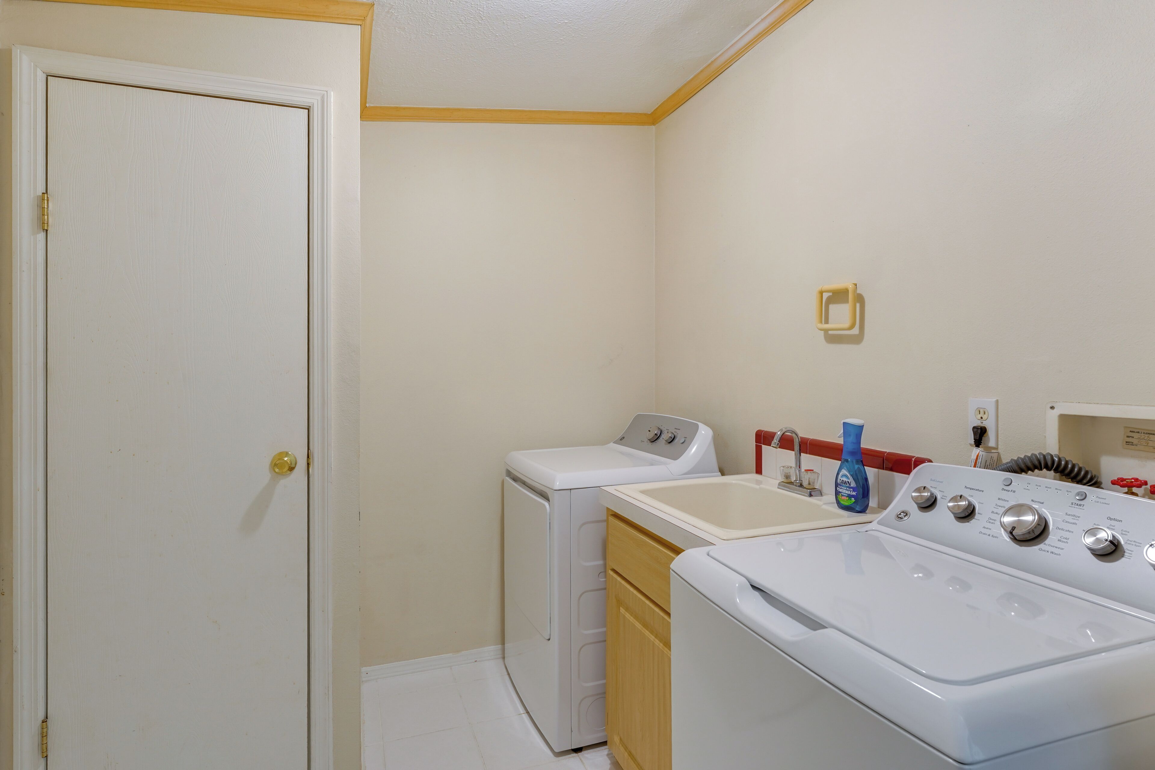 A laundry room with a washing machine, dryer, and stacked washer-dryer unit.