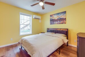 A bedroom with a bed, a nightstand, a dresser, a ceiling fan, an air conditioning unit, and a window with blinds. - Close to Downtown Ashland! Convenient Suite (Ashland)