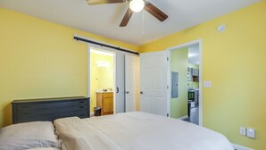 Un dormitorio con cama, cómoda y ventilador de techo.