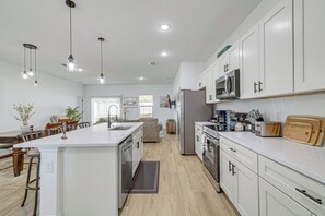 A modern kitchen with white cabinets, stainless steel appliances, and pendant lighting. - 6 Mi to Trails! Tranquil Home w/ Yard in Ocala (Ocala)