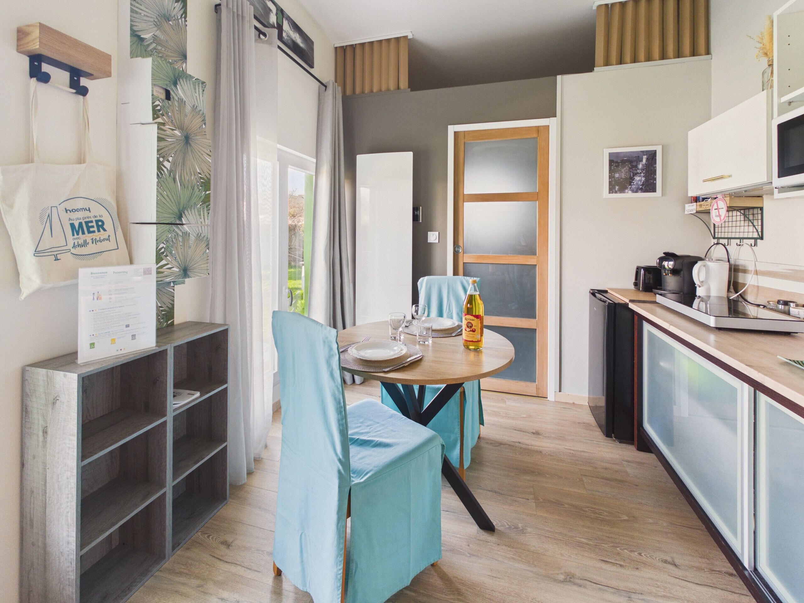 A modern kitchen with a dining area, wooden cabinets, and a view of the outdoors.