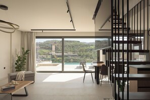 Ein modernes Wohnzimmer mit einem großen Schiebeglastür, die auf einen Balkon mit schöner Aussicht führt.