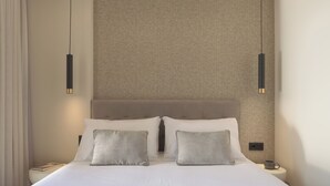 Een moderne hotelkamer met een groot bed, twee nachtkastjes en een structuurwand.