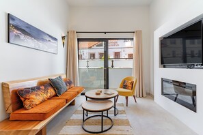 A modern living room with a sofa, armchair, coffee table, and a fireplace. - TRES PINOS APARTMENT (Mijas)