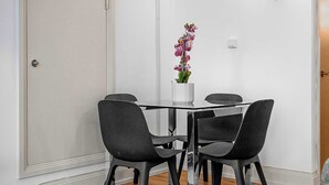 A dining area with a table, chairs, and a potted plant. - Elegant Soho 1-Bed - Balcony, 2 Baths, Sleeps 4 (London)