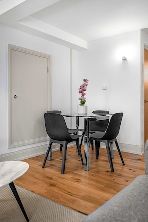 A dining area with a table, chairs, and a potted plant. - Elegant Soho 1-Bed - Balcony, 2 Baths, Sleeps 4 (London)