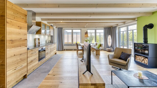 A spacious living area with a wooden floor, a flat-screen TV, a sofa, and a fireplace. - 5* vacation home 188sqm with high-quality comfort with 4 bedrooms and space for 7 people (Sankt Andreasberg)