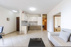 Eine moderne Wohnung mit Küche, Wohnbereich und einem kleinen Balkon.