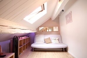 Un dormitorio acogedor en el ático con cama tipo litera, estanterías de madera y un tragaluz.