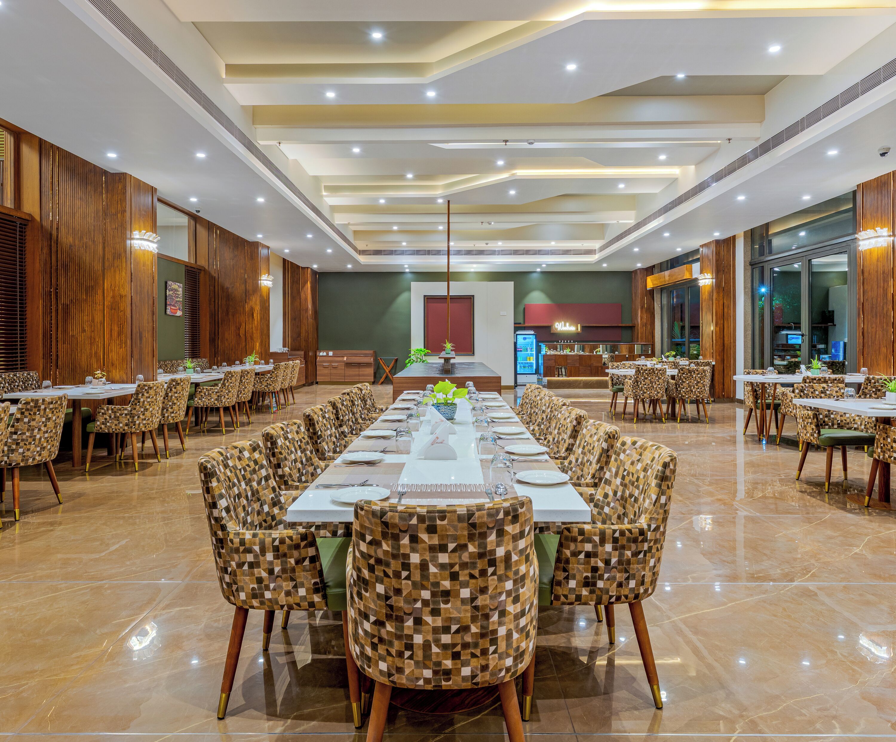 A spacious dining area with high ceilings, modern lighting, and checkered chairs.