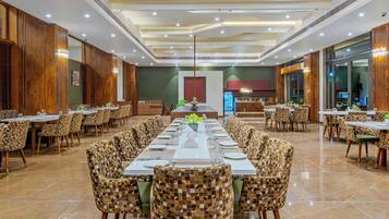 A spacious dining area with high ceilings, modern lighting, and checkered chairs.