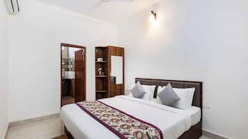 A bedroom with a bed, bedside tables, a wardrobe, a ceiling fan, and a wall-mounted light fixture.