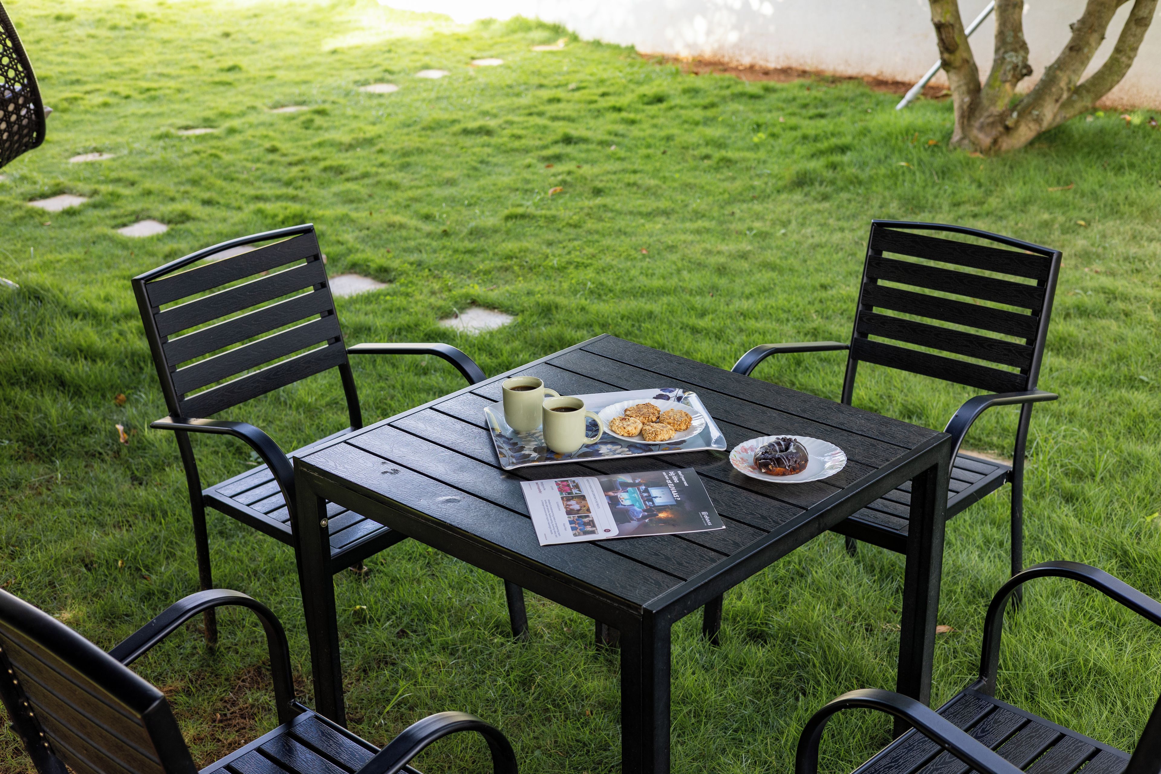 A table with chairs in a grassy outdoor area.