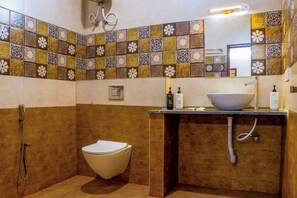 Une salle de bain avec des toilettes, un lavabo et une douche.
