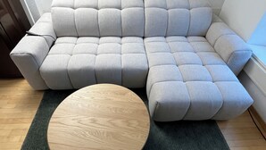 A sectional sofa with a wooden coffee table in front. - ODA Suites (Lucerne)