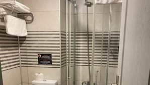 Ein Badezimmer mit Duschkabine, Toilette und Waschbecken.