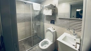 Ein modernes Badezimmer mit einer Duschkabine, einer Toilette und einem Waschbecken.