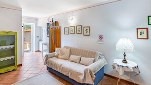 A cozy living room with a sofa, a small table with a lamp, and a green cabinet. - Former convent with private pool in Tuscany (Camaiore)