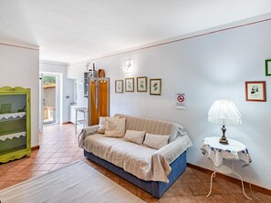 A cozy living room with a sofa, a small table with a lamp, and a green cabinet. - Former convent with private pool in Tuscany (Camaiore)