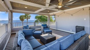 A covered outdoor seating area with wicker furniture and a ceiling fan. - Nst108 4 Bedroom Home (Punta Gorda)