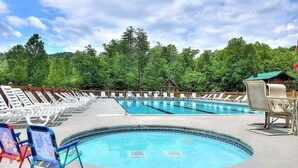 Une piscine équipée de chaises longues et d’un poste de surveillance pour les sauveteurs.