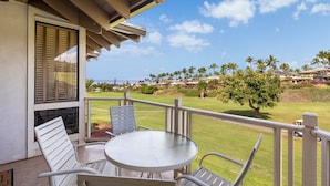 A balcony with a table and chairs, overlooking a golf course and a residential area. - Wailea Grand Champion, #78 2 Bedroom Condo (Kihei)