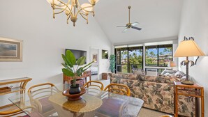 A dining area with a glass table, chairs, and a potted plant. - Wailea Grand Champion, #78 2 Bedroom Condo (Kihei)