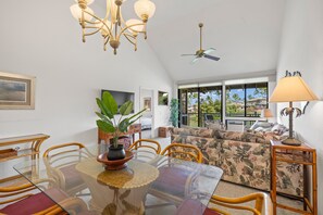 A dining area with a glass table, chairs, and a potted plant. - Wailea Grand Champion, #78 2 Bedroom Condo (Kihei)