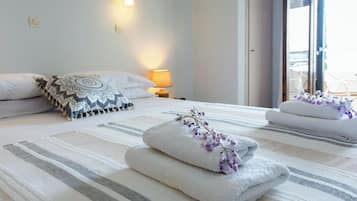 Ein Hotelzimmer mit Bett, Nachttischlampe und Blick ins Freie.