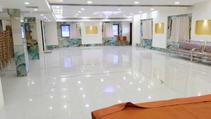 A spacious, well-lit hotel lobby with a polished floor, seating areas, and a large screen. - The City Park Hotel  (Hyderabad)
