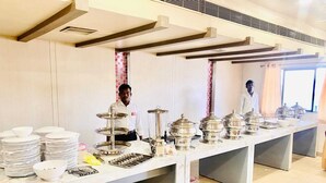 A kitchen area with stainless steel serving ware, including plates, bowls, and tureens, arranged on a counter. - The City Park Hotel  (Hyderabad)