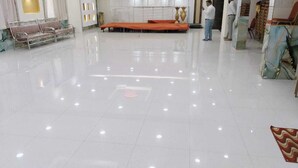 A spacious, well-lit room with a tiled floor, a red mat, and a row of chairs. - The City Park Hotel  (Hyderabad)
