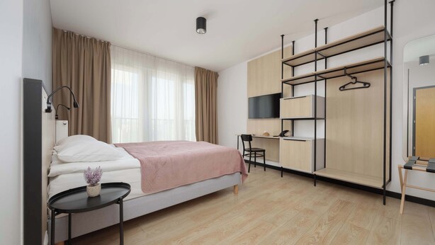 Une chambre moderne avec un lit, un bureau et une armoire.