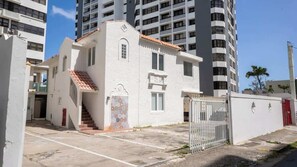 Ein Gebäude mit weißer Fassade, rotem Ziegeldach und einem verschlossenen Eingang.