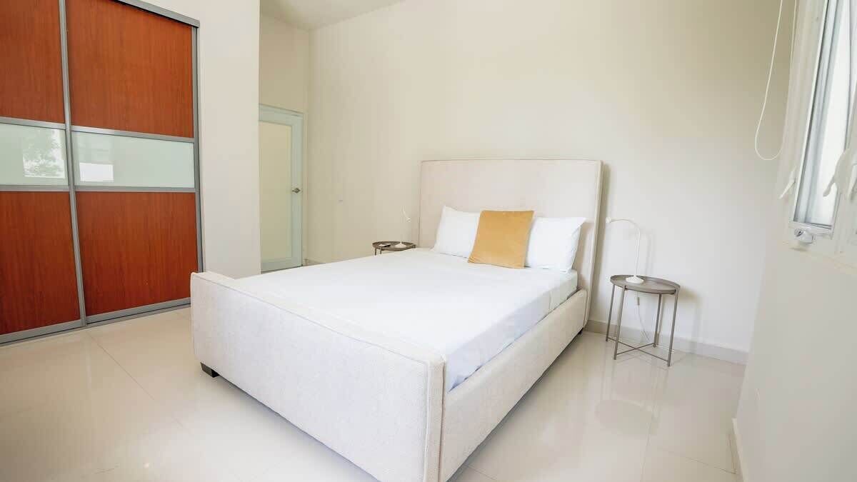 Ein Schlafzimmer mit Bett, Nachttisch, Kleiderschrank und Fenster.