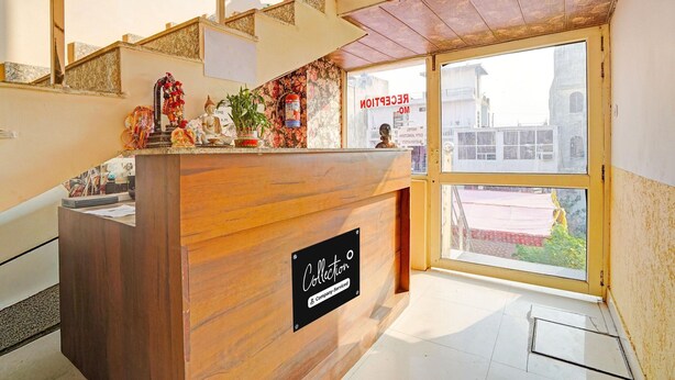 A reception desk with a sign reading 'Collector Company Services,' a potted plant, and a fire extinguisher. - Classic Hotel Haveli inn (Meerut)
