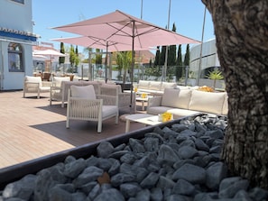 A rooftop terrace with outdoor seating, umbrellas, and a view of the surrounding buildings. - Hotel Santa Eulália Bay (Albufeira)