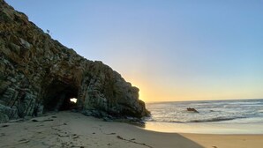 A beach with a rocky cliff and a cave entrance. - Oceanfront Apartment Estudio el Suspiro (Tunquen)