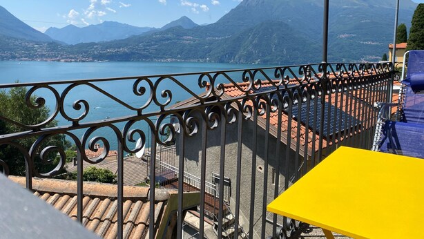 Un balcon avec vue sur un lac et des montagnes.
