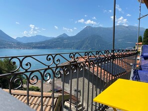 Een balkon met uitzicht op een meer en bergen.