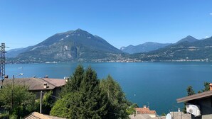 Un paysage montagneux avec un lac et des immeubles d’habitation.