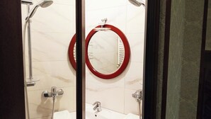 A bathroom with a glass partition, a white sink, a mirror with a red frame, and a shower area. - Room N 6 by Kraveli (Tbilisi)