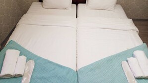 A double bed with white linens, two pillows, and a teal-patterned bed runner. - Room N 6 by Kraveli (Tbilisi)