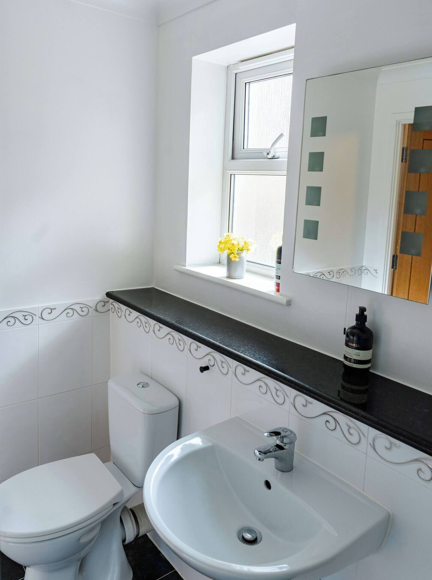 Ein Badezimmer mit Toilette, Waschbecken und Fenster.
