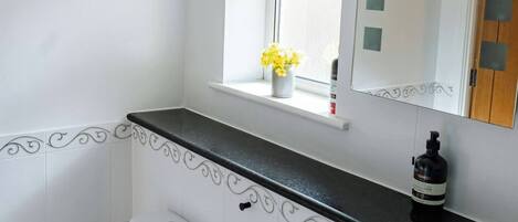 Ein Badezimmer mit Toilette, Waschbecken und Fenster.